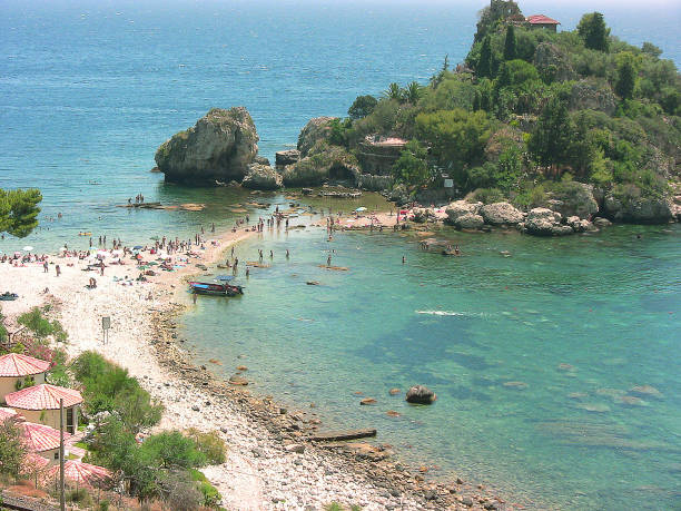 detail of the famous beach of Isola Bella from the street on a sunny day Taormina, Sicily, Italy - July 14, 2010: detail of the famous beach of Isola Bella so called by the name of the island which distinguishes it, from the street on a sunny day. You see many bathers far away isola bella taormina stock pictures, royalty-free photos & images