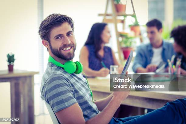 Smiling Young Man Using Digital Tablet Stock Photo - Download Image Now - 20-24 Years, 20-29 Years, 30-34 Years