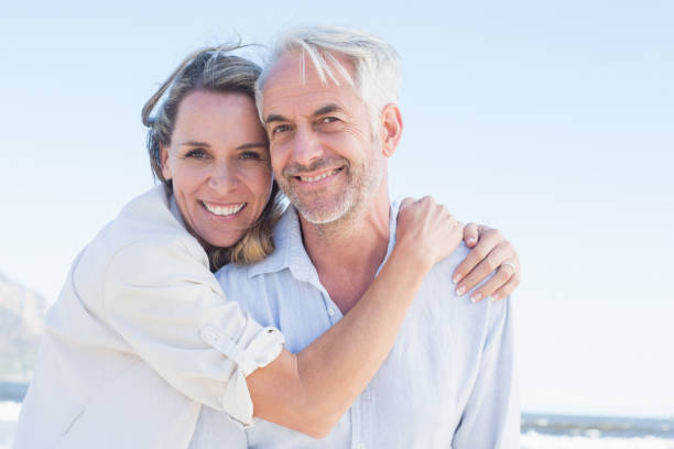 istock Attractive couple hugging at the beach smiling at camera 692201116