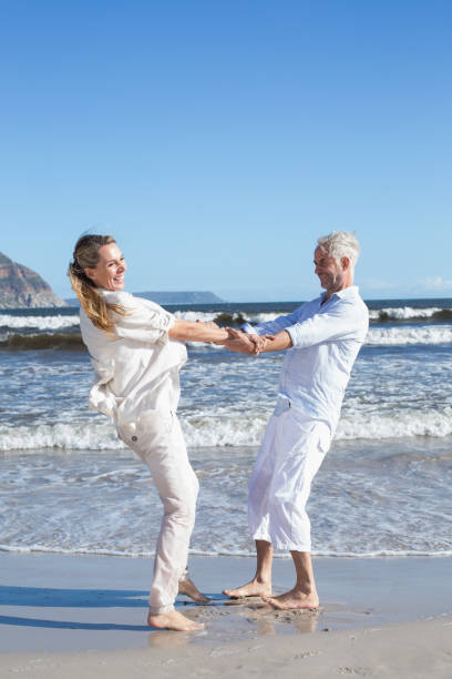 istock Smiling couple spinning on the beach 692201630