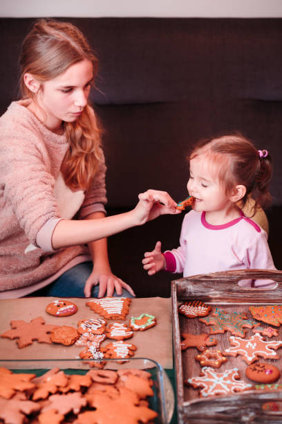 istock Sisters tasting Christmas gingerbread cookies 692211482