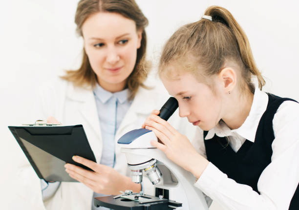 istock Woman and little girl using microscope in laboratory. 692212146