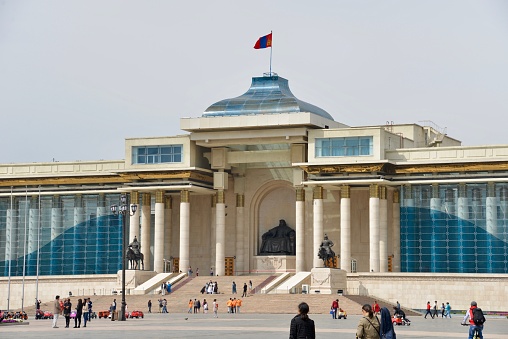 Ulaanbataar, Monogolia - August 19, 2015: Chinggis Square, still commonly referred to as Sükhbaatar Square, is the central square of Mongolia's capital Ulaanbaatar. It is also a primary gathering place for families, tourists and wedding parties, who take pictures in front of Chinggis Khan's statue. The main government building is in the background.