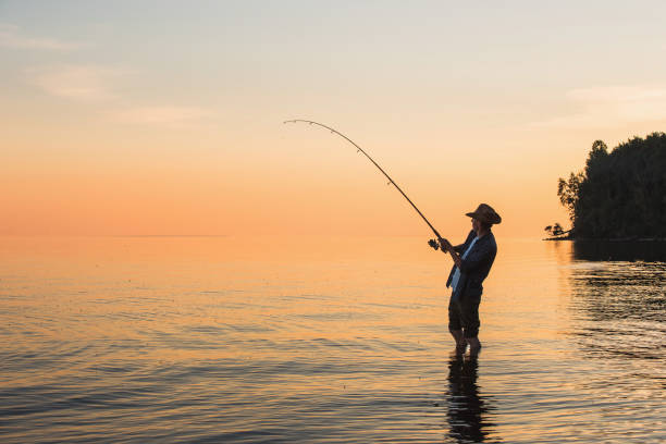 istock Fisherman at lake on sunset 692221556