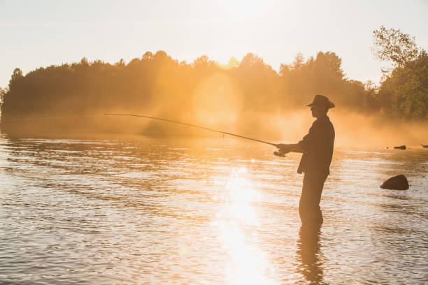 istock Fisherman at lake on sunset 692224392