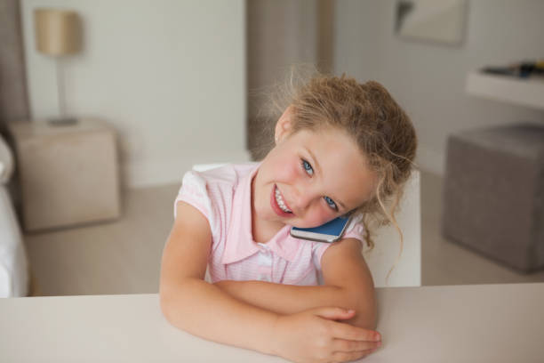istock Smiling young girl using mobile phone 692230884