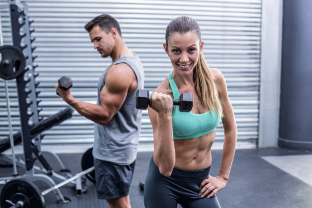 istock A muscular couple lifting dumbbells 692234912