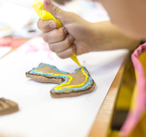 istock Girl decorates cookies with paint 692237656