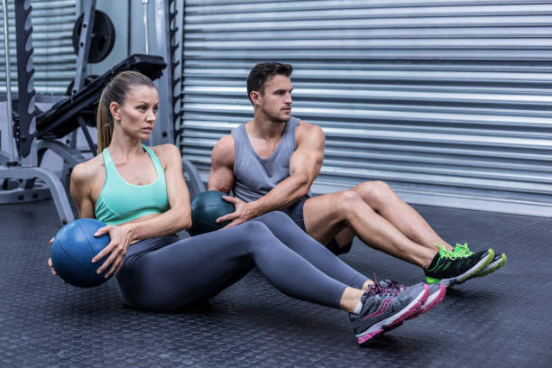 istock Muscular couple doing abdominal ball exercise 692240016