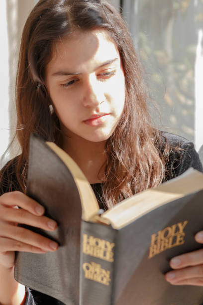 istock Girl reads the Bible 692243878