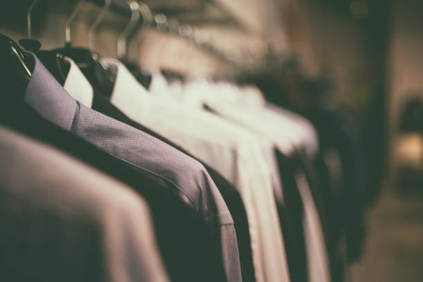 toma de primer plano de blusas azules con coathangers en un estante de la ropa. - barra para colgar la ropa fotografías e imágenes de stock