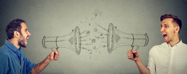 istock Quarrel between two men screaming at each other in megaphone 692253632