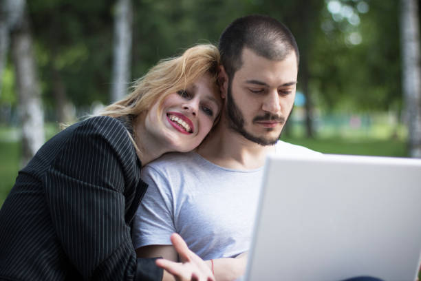 istock Young couple using laptop in the park 692259414