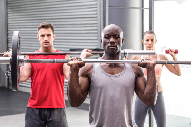 istock Three muscular athletes lifting barbells 692259536