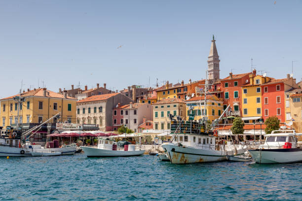 Rovinj City Harbor Croatia Famous and colorful Rovinj harbor waterfront with tourist boats, fisherboats, restaurants, shops and colorful houses. Church of St. Euphemia in the background on the top. Rovinj - Rovigno, Istria, Croatia, Europe. rovinj harbor stock pictures, royalty-free photos & images