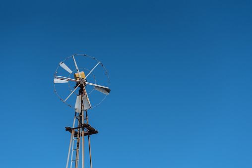 Rusted Windmill in the Desert on Blue Sky