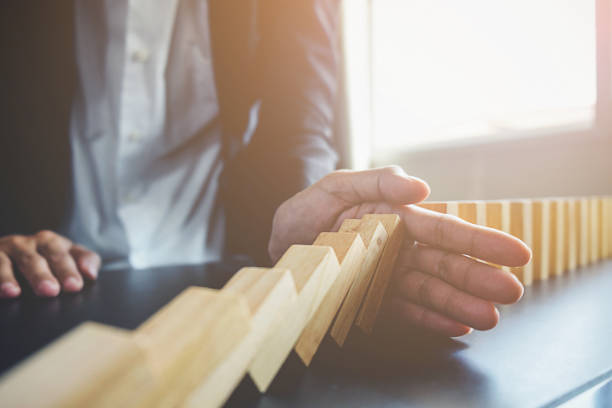 solutions aux problèmes, la vue sur la main de business woman arrêt chute blocs sur table pour concept sur la prise en charge de près. - risk management photos et images de collection