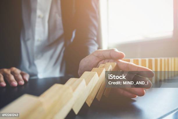 Problem Solvingclose Up View On Hand Of Business Woman Stopping Falling Blocks On Table For Concept About Taking Responsibility Stock Photo - Download Image Now