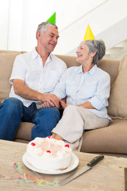 istock Senior couple sitting on couch celebrating a birthday 692263908