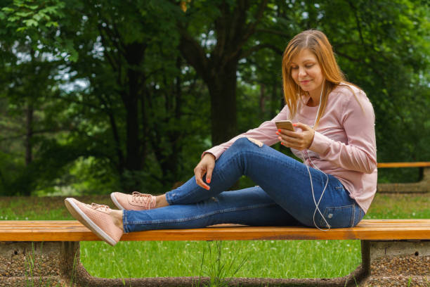 istock Young woman texting on smart phone outdoors 692271374