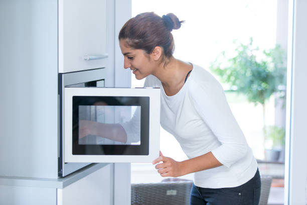 Woman using a microwave stock photo