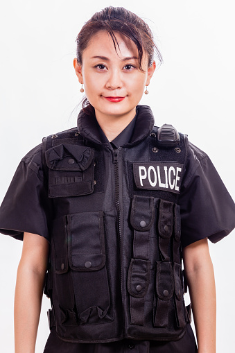 female police detective close up of showing her badge, gun and handcuffs, walkie-talkie