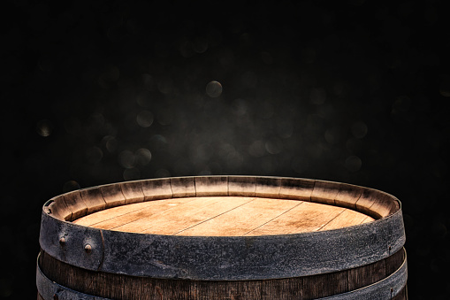 Image of old oak wine barrel in front of black background. Useful for product display montage. Vintage filtered
