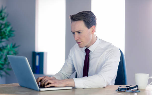 istock Serious businessman typing on laptop 692276644