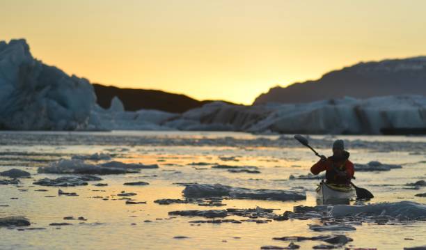 Iceland paddling A kayaker paddles through Icebergs on Jokulsarlon lagoon. jokulsarlon stock pictures, royalty-free photos & images