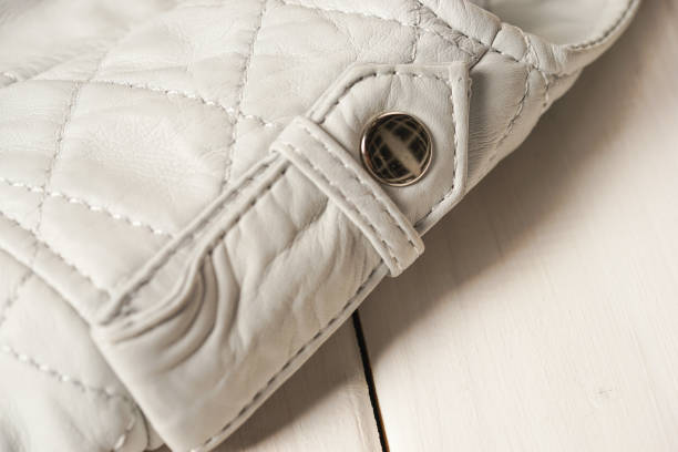 istock Metal clasp button on white leather jacket. White background. Macro detail 692285584