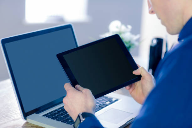 istock Rear view of businessman using tablet 692291596