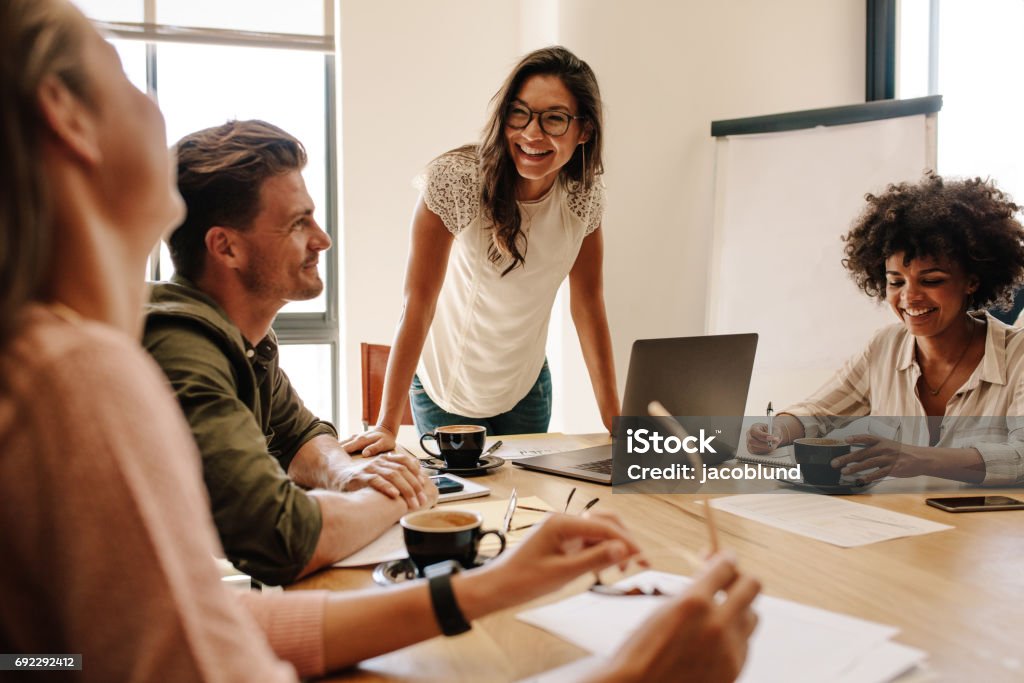 Group of multi ethnic executives discussing during a meeting Group of multi ethnic executives discussing during a meeting. Business man and woman sitting around table at office and smiling. Teamwork Stock Photo