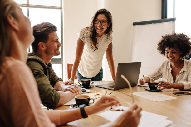 Group of multi ethnic executives discussing during a meeting Group of multi ethnic executives discussing during a meeting. Business man and woman sitting around table at office and smiling. happy workers stock pictures, royalty-free photos & images