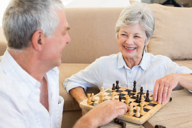 istock Senior couple sitting on floor playing chess 692295166