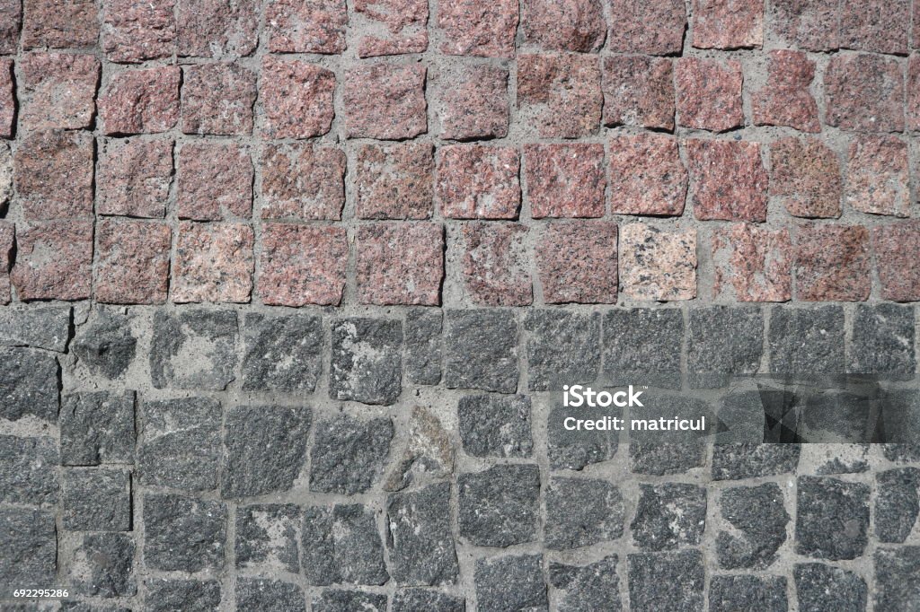 Rubble gray and brown square stones paved road with a horizontal border Asphalt Stock Photo