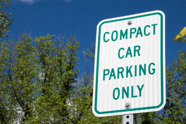 istock Compact car parking only sign against treetops 692303534