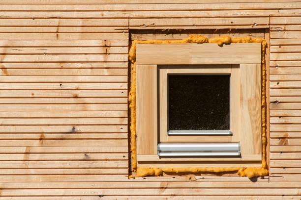 Wooden window. Foam window insulation on wooden construction.