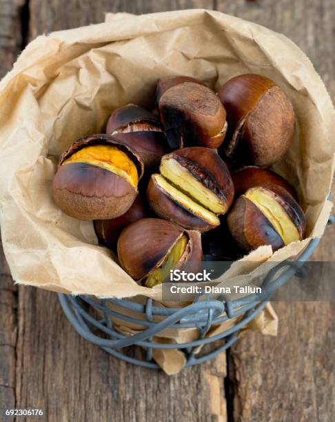 Roasted Chestnuts On Wooden Surface Stock Photo - Download Image Now - Arrangement, Border - Frame, Bucket
