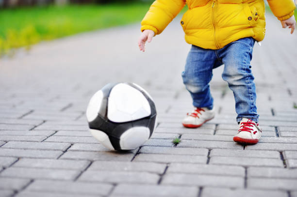 Little boy having fun playing a soccer game on sunny spring or autumn day