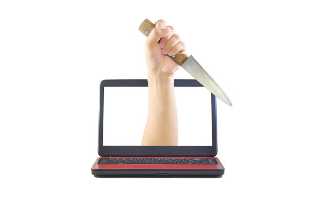 Stabbing hand with knife coming out of computer monitor A hand holding a knife coming out of a laptop screen. White isolated background. Visual representation for cyber bullying and cybercrime. coming out of computer screen stock pictures, royalty-free photos & images