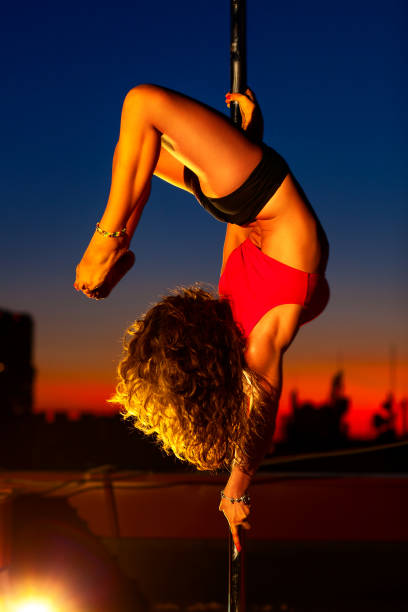 молодая женщина танец полюса - pole vibrant color dancer exercising стоковые фото и изображения