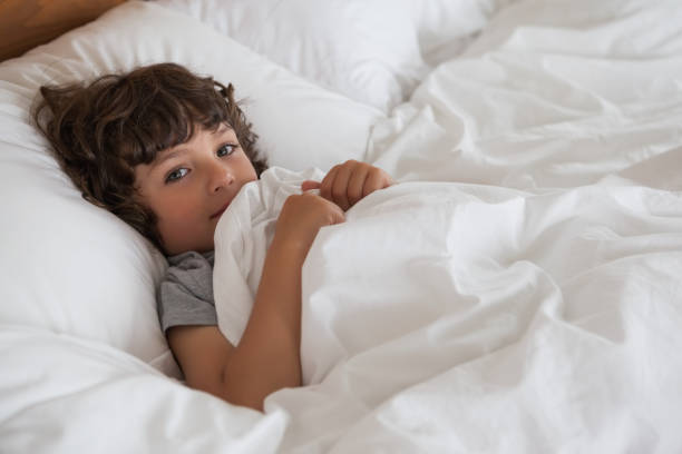 istock High angle portrait of a boy resting in bed 692319588