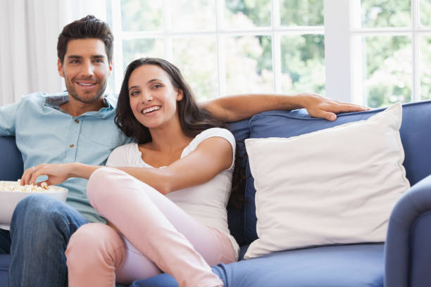 istock Attractive couple watching tv on the couch 692328782