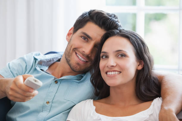 istock Attractive couple watching tv on the couch 692328804