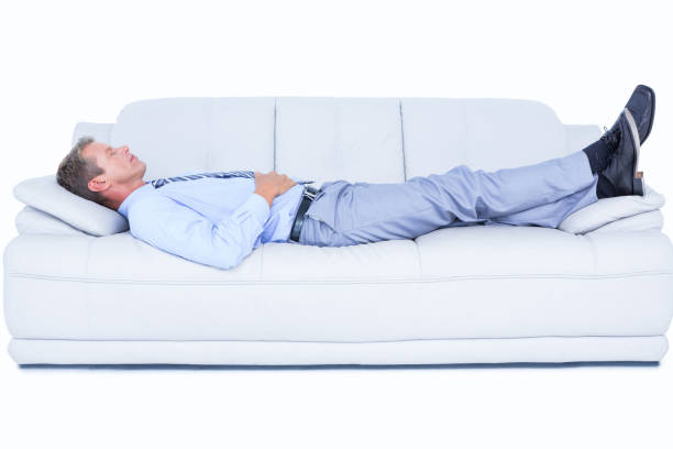 istock Tired businessman lying on the sofa 692342882