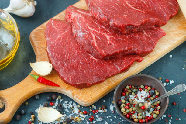 istock Fresh raw meat. Beef steaks and spices on the table. 692343578