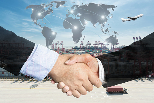 Double Exposure of a businessman handshake  with Map global partner connection of Container Cargo freight ship for Logistic Import Export background