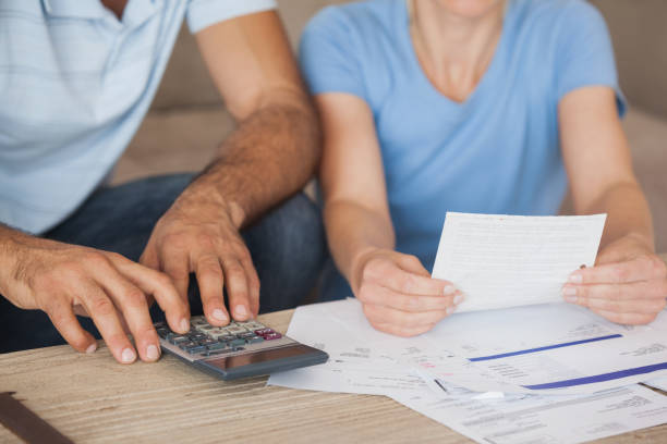 istock Mid section of a couple with bills and calculator 692347486