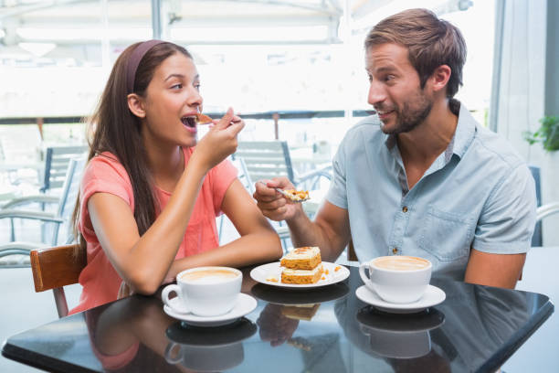 istock Young happy couple eating cake together 692354618