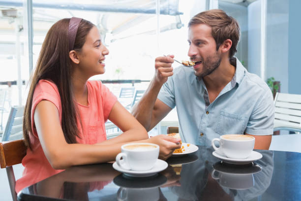istock Young happy couple eating cake together 692354650